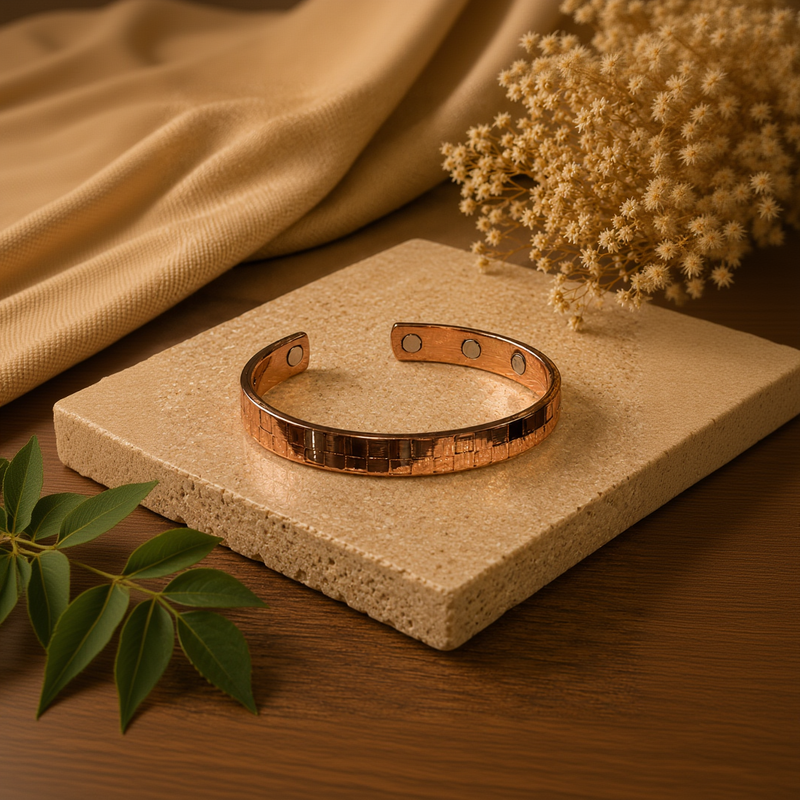 Rose gold bracelet on a textured surface with a neutral background